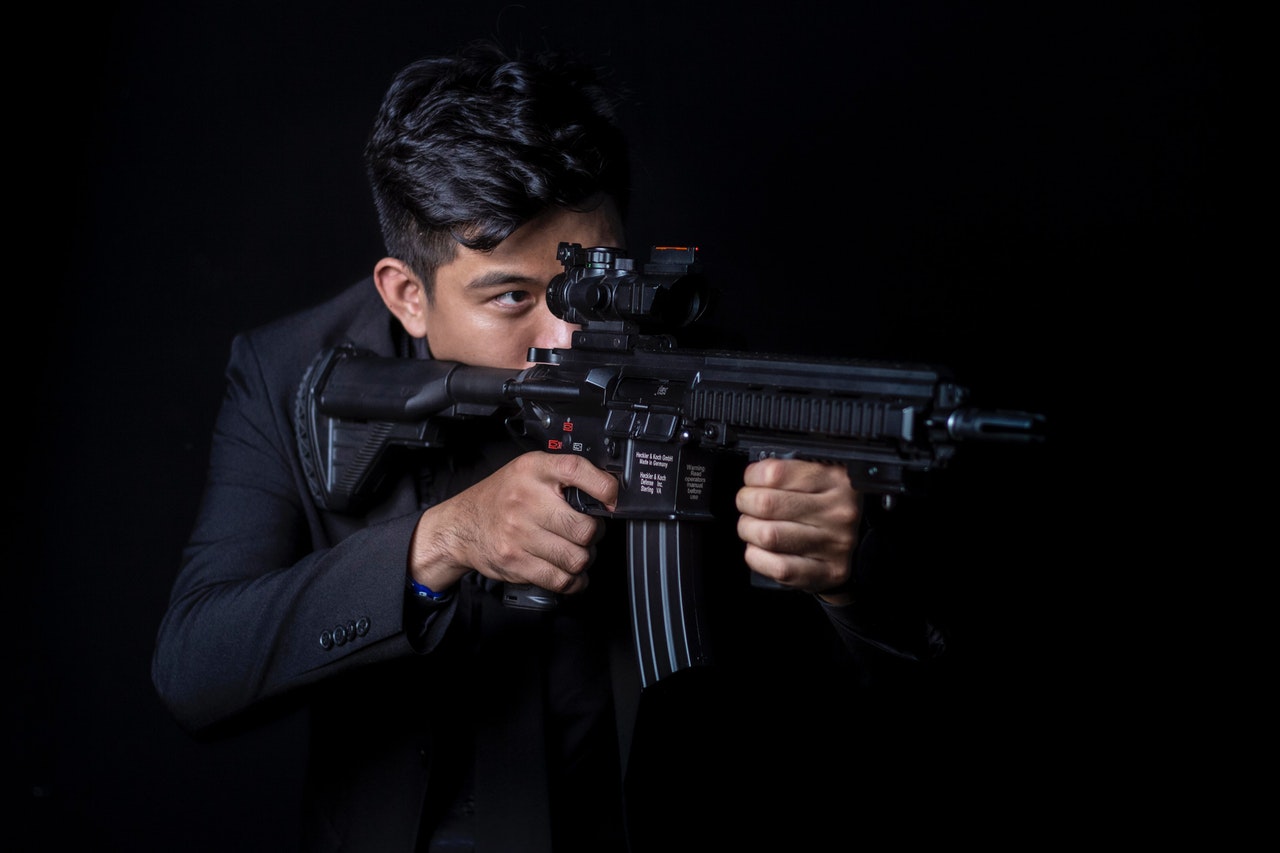 black themed armed person aiming his ar15 to something